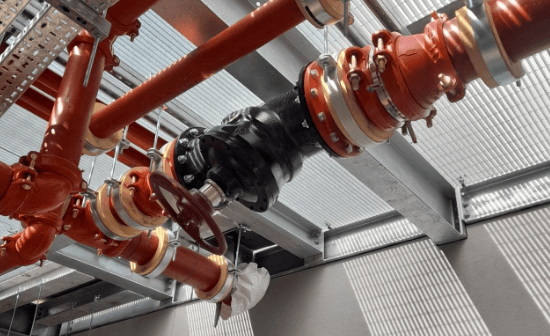 Heavy duty pipes and valves installed aloft in an open air building